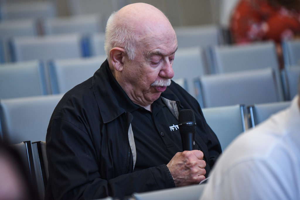 Fr. Bob Karris sits in the prayer room at FFTP headquarters. He is speaking into a microphone.